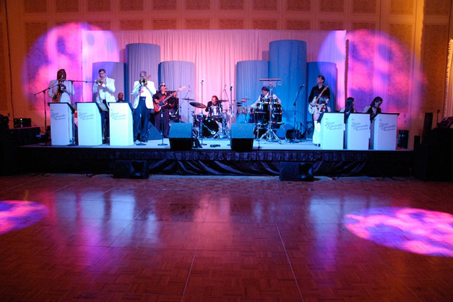 Band performing on stage with colorful lights.