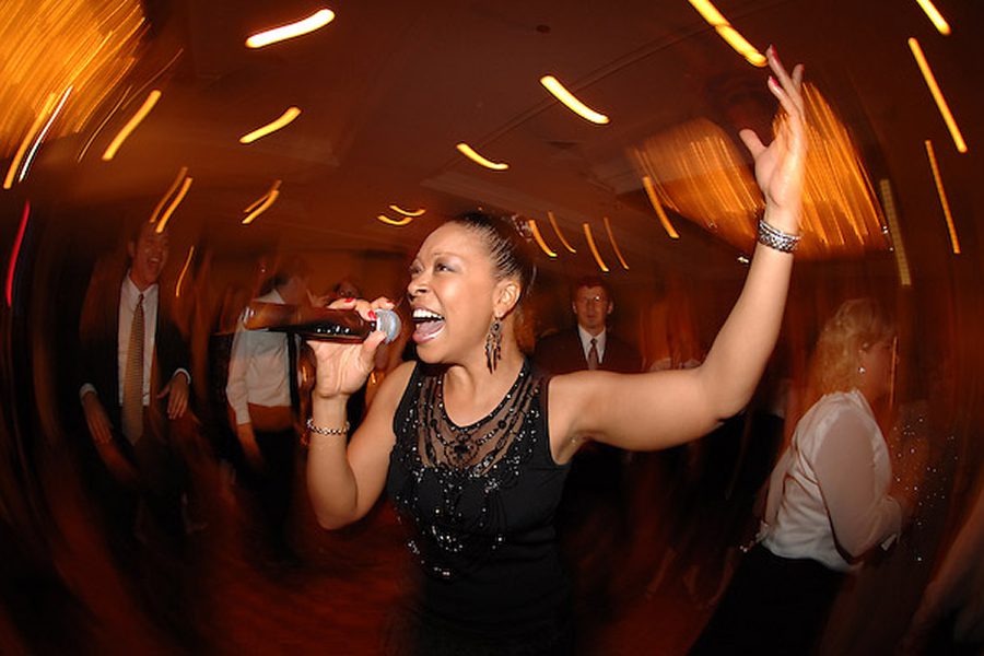 Singer performing energetically at a lively event.