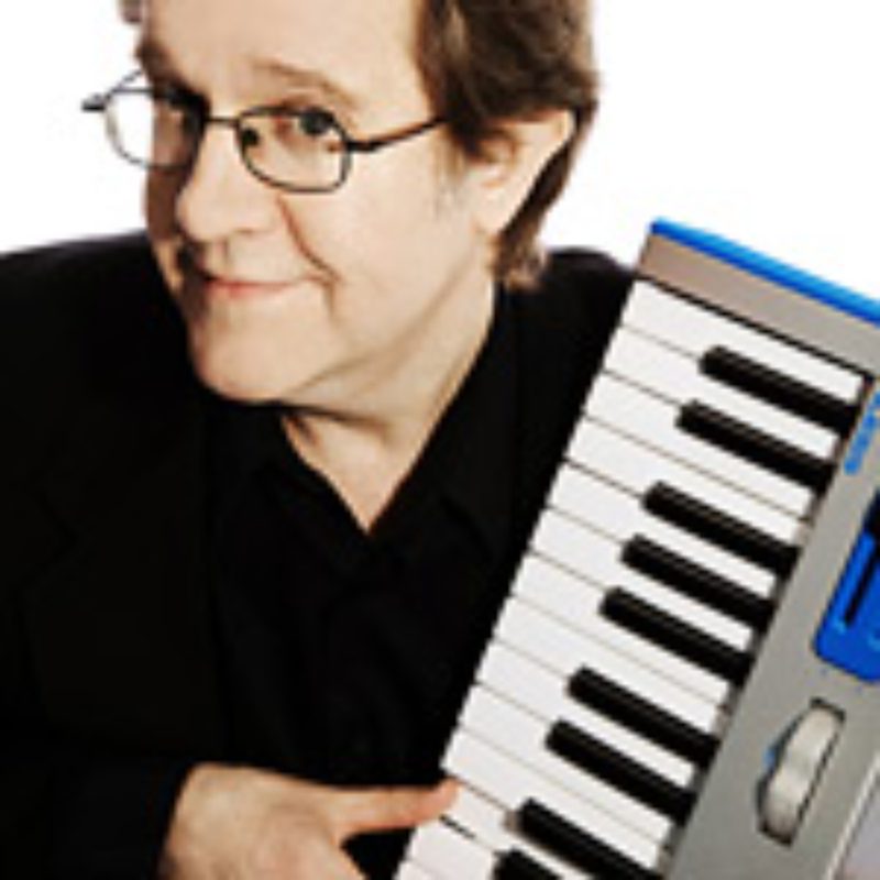 Person smiling, holding a keyboard instrument.