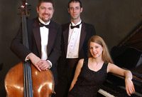Musicians posing with instruments in formal attire.
